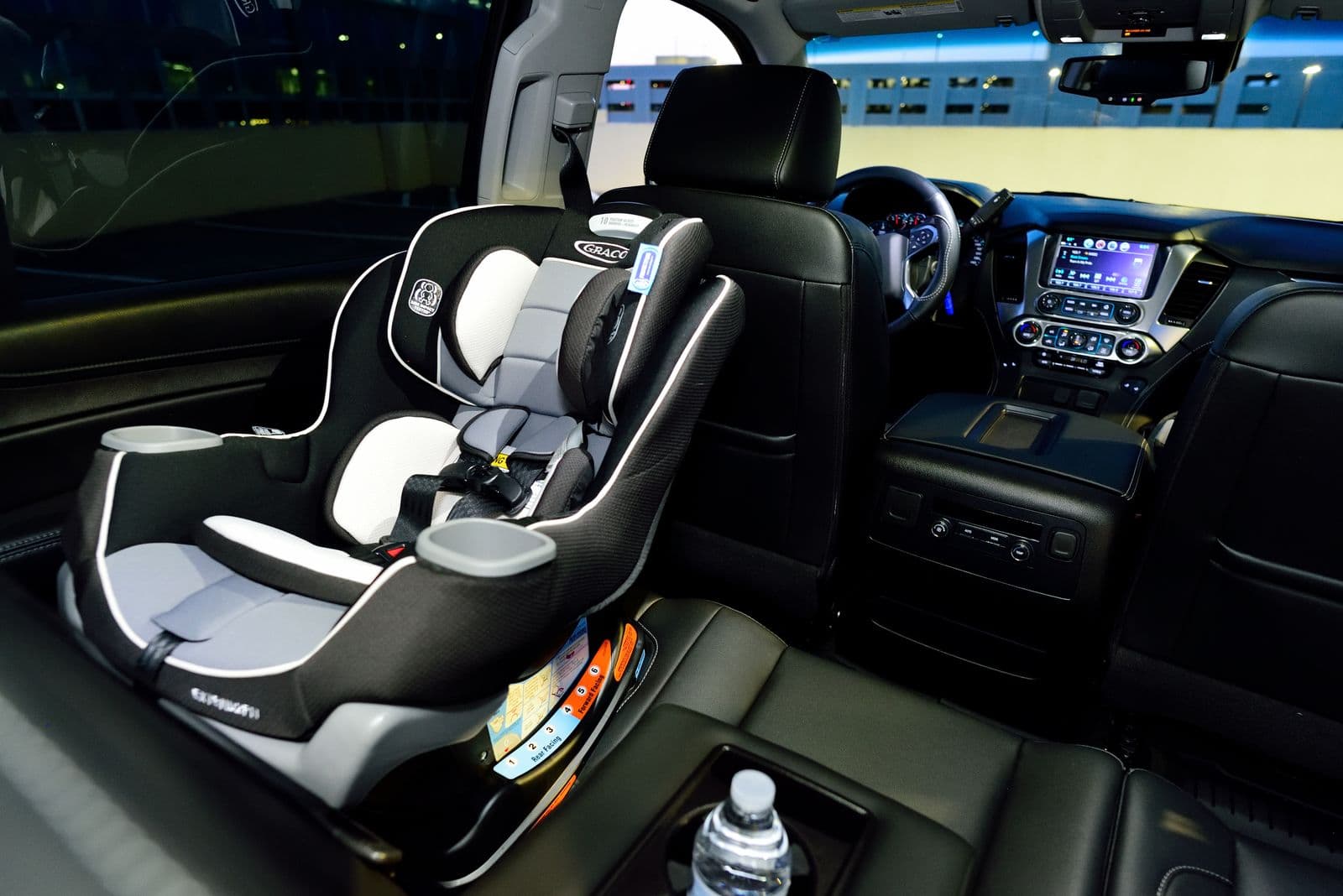 A child safety seat installed in the back of a car at night